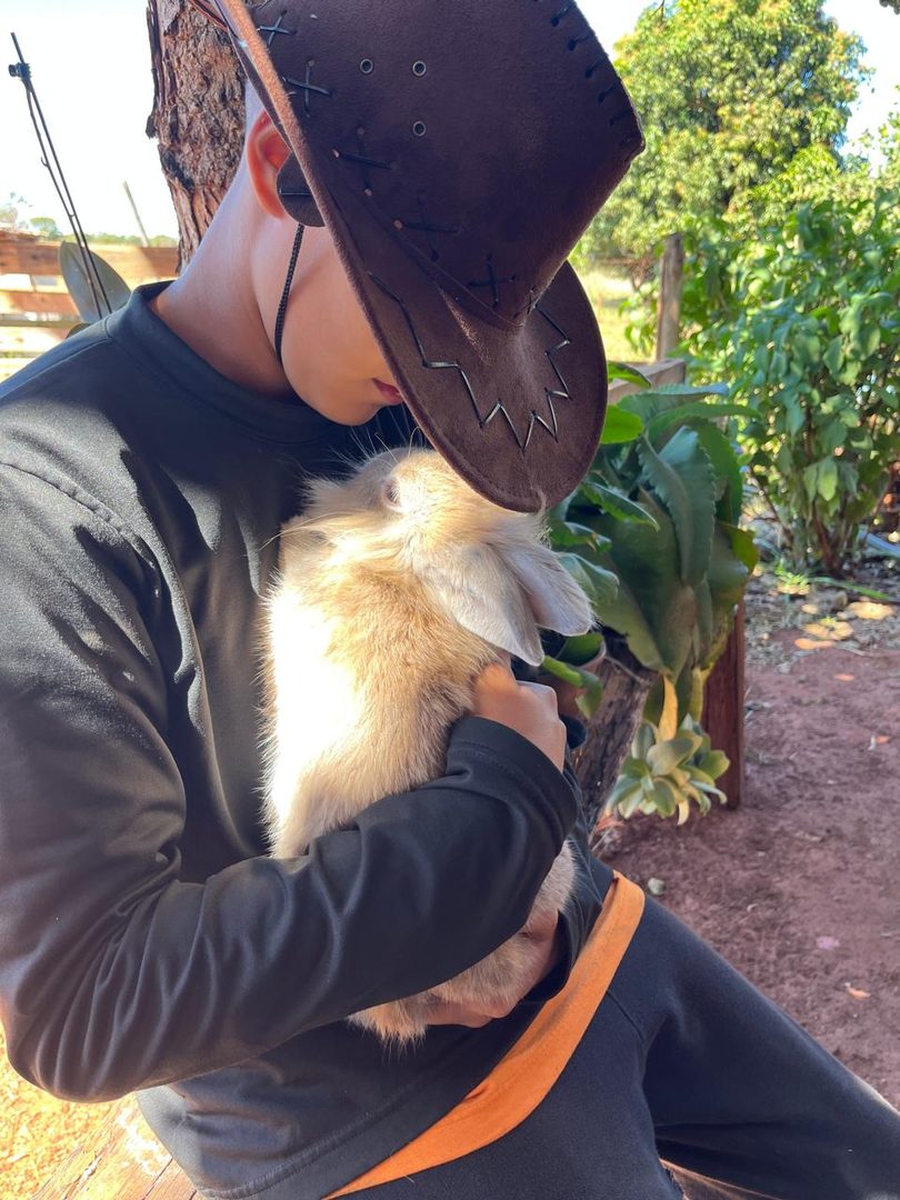 Criança com um cabritinho no colo